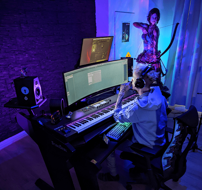 Tobi Weiss sitting in front of his computer mixing a track in his studio